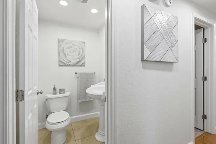 Convenient main-level powder room with pedestal sink, ideal for guests.