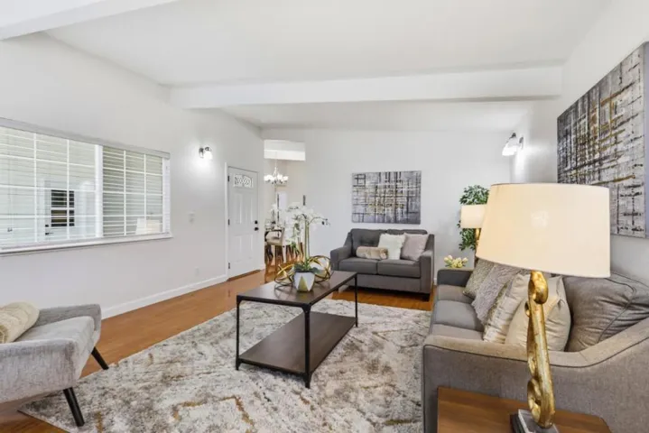 Open-concept living room with hardwood flooring and seamless flow to the dining area.