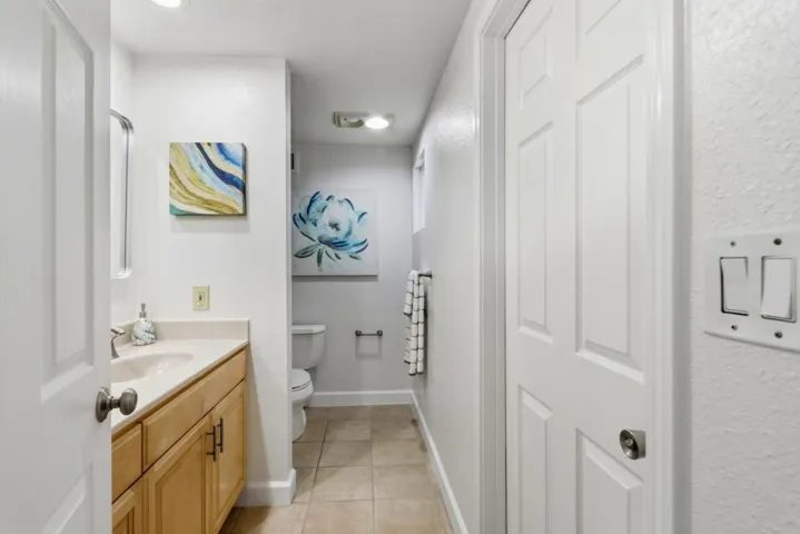 Additional full bathroom with extended vanity, ample storage, and a private tub and toilet area.
