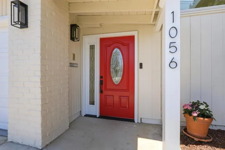 Inviting front entry with a vibrant red front door and contemporary lighting.