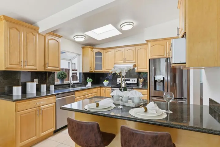 Well-appointed kitchen with granite countertops, stainless steel appliances and breakfast bar.