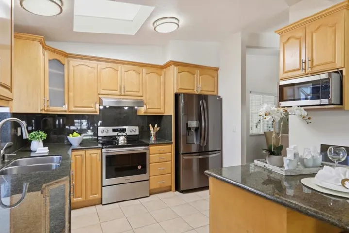 Bright kitchen featuring granite countertops, stainless steel appliances and generous cabinet space.
