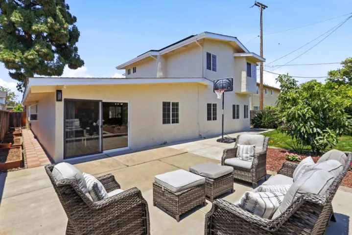 Backyard with generous patio space, mature landscaping, and plenty of room for outdoor enjoyment.