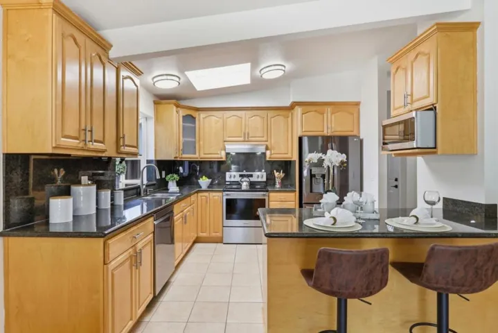 Spacious kitchen offering abundant cabinetry, granite countertops, and a functional peninsula.