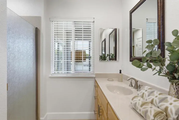 Spacious primary bathroom showcasing a dual-sink vanity, oversized mirrors, and ample cabinetry.