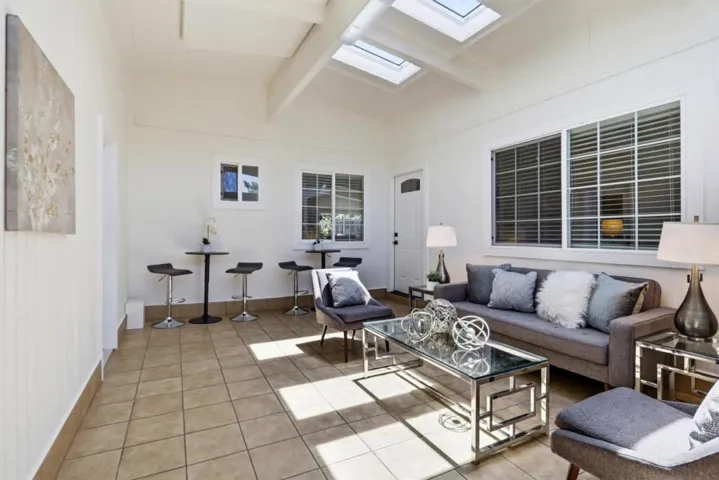 Bright sunroom with vaulted ceilings, skylights, and abundant natural light.