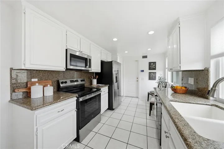 Gally Kitchen with Granite counter top, built in microwave, new stove, freshly painted cabinets, staged.