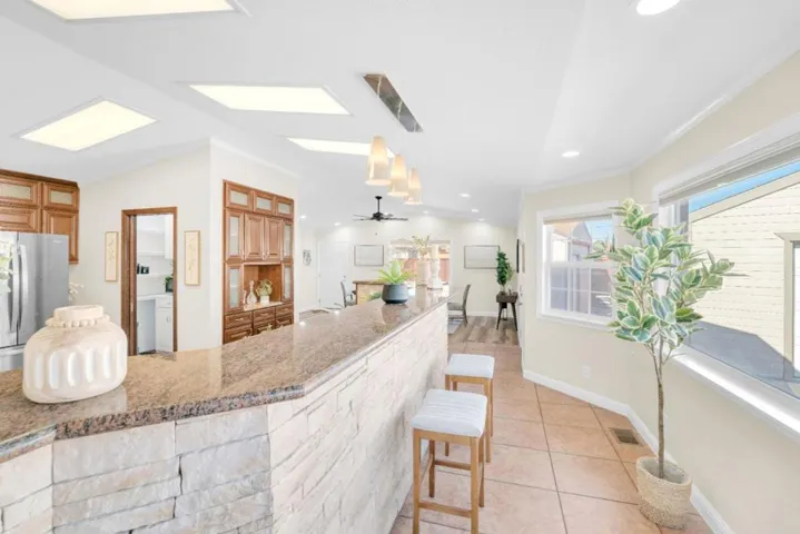Stone-faced island bar with granite. Open to dining.