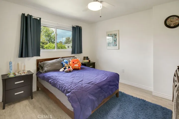 Bright secondary bedroom offers generous space, large windows, and luxury vinyl flooring.