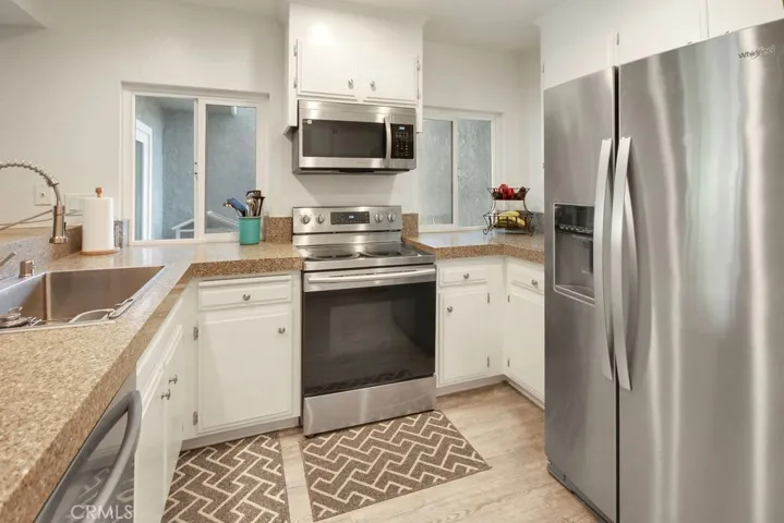 Updated kitchen features recently refinished cabinetry, stainless steel appliances, and abundant counter space.