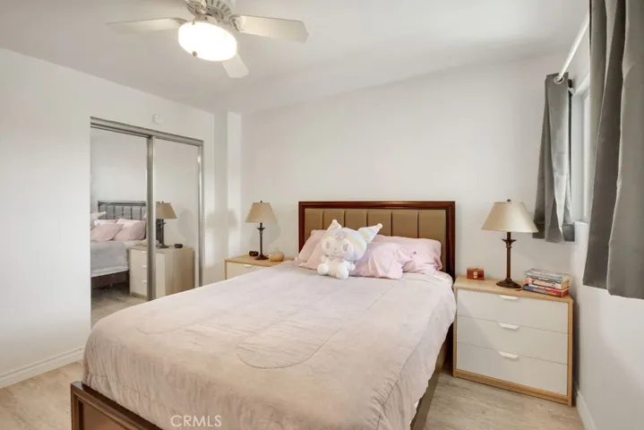 Comfortable secondary bedroom offers abundant natural light and mirrored closet doors.