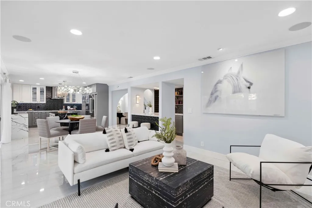 Adjacent to the kitchen, the expansive family room features sleek flooring, a cozy remote-controlled fireplace, a convenient wet bar