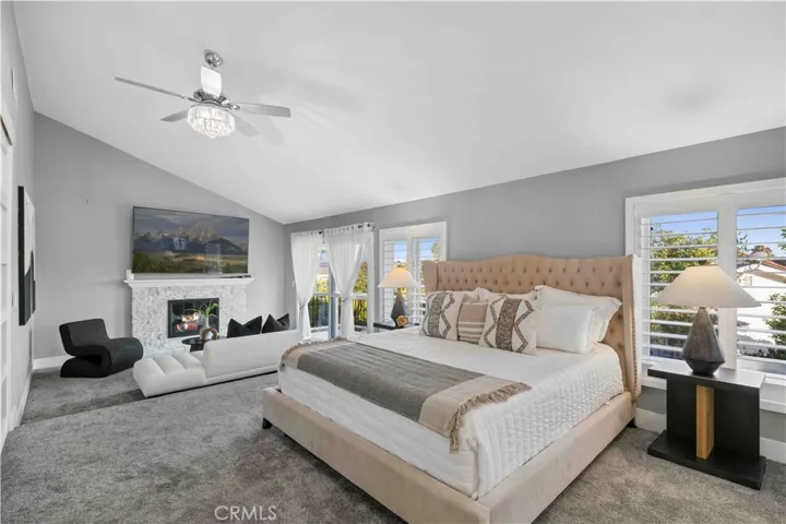 Upstairs, the spacious primary suite serves as a luxurious retreat with vaulted ceilings, a remote-controlled fireplace