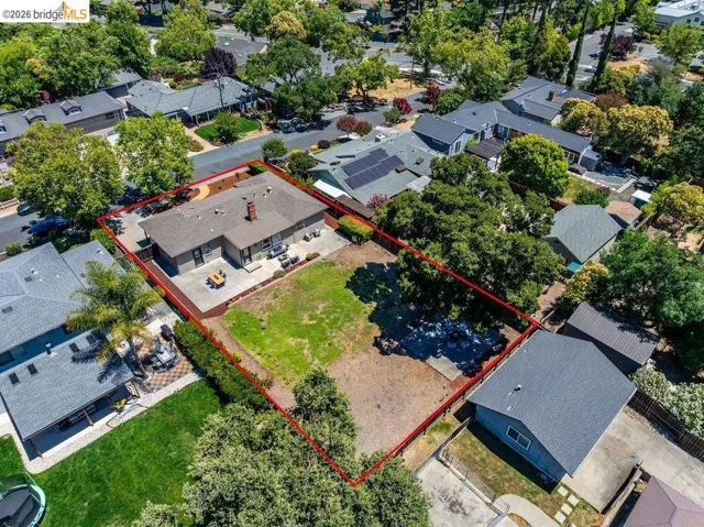 Expansive property featuring a single-story residence with a gray shingle roof and brick chimney
