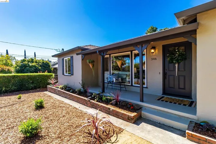 Front entry featuring a dark-toned door, covered porch, and exposed rafter tails
