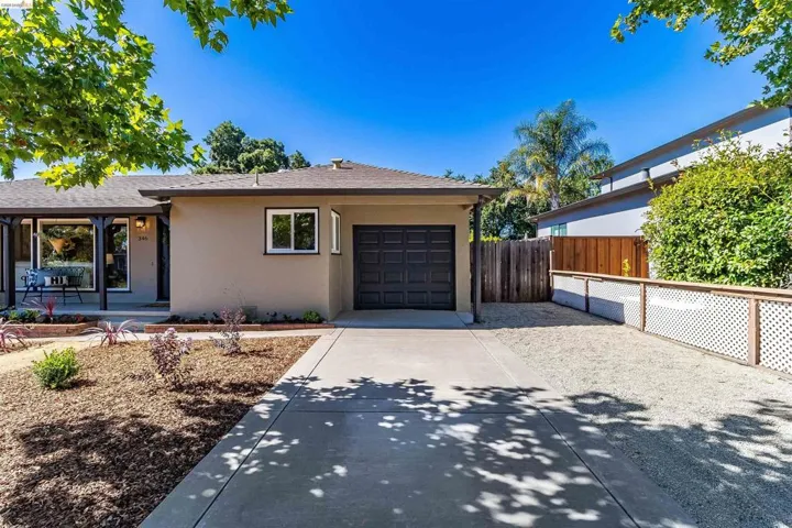 Single-story residence featuring a tan stucco exterior, dark brown garage door, and a covered porch entry