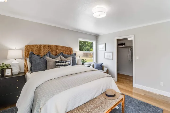 Spacious bedroom featuring light wood-finish flooring, a window offering exterior views, and a closet with a built-in hanging rod