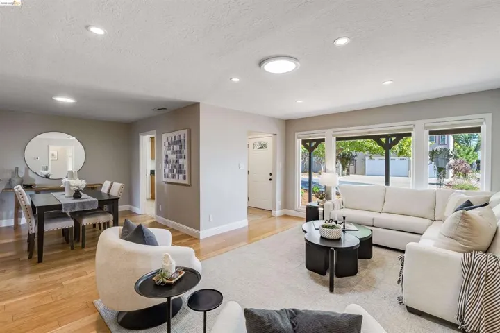 Open concept living area featuring wood-finish flooring, recessed lighting, and a dining space with a dark wood table