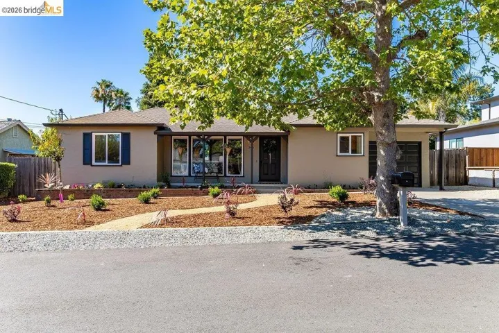 Single-story residence featuring a neutral-toned exterior, dark trim, and a prominent front entry with a dark door