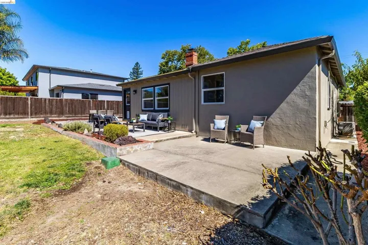 Expansive concrete patio area extending from the home, offering multiple zones for outdoor living