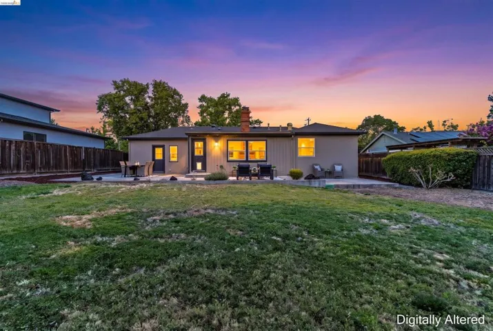 Expansive backyard featuring a large grass lawn and a concrete patio