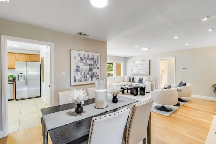 Open-concept living and dining area featuring recessed lighting, light wood-finish flooring, and light-toned walls