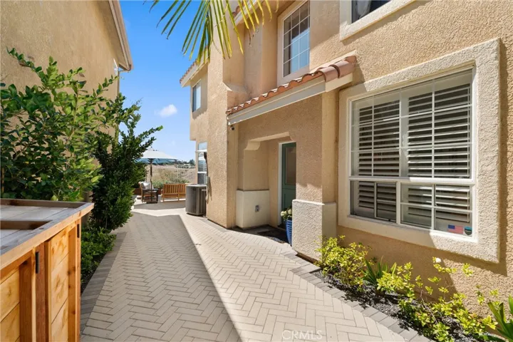 Inviting herringbone-paver walkway leading to the private front entrance