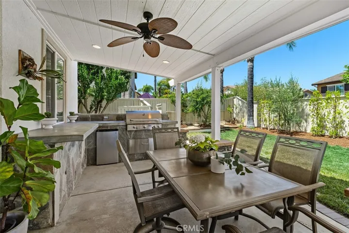 Built-in barbeque, small refrigerator and concrete countertops and stone front