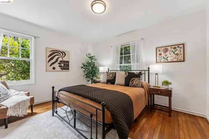 Room featuring wood-finish flooring, white walls, and bright windows