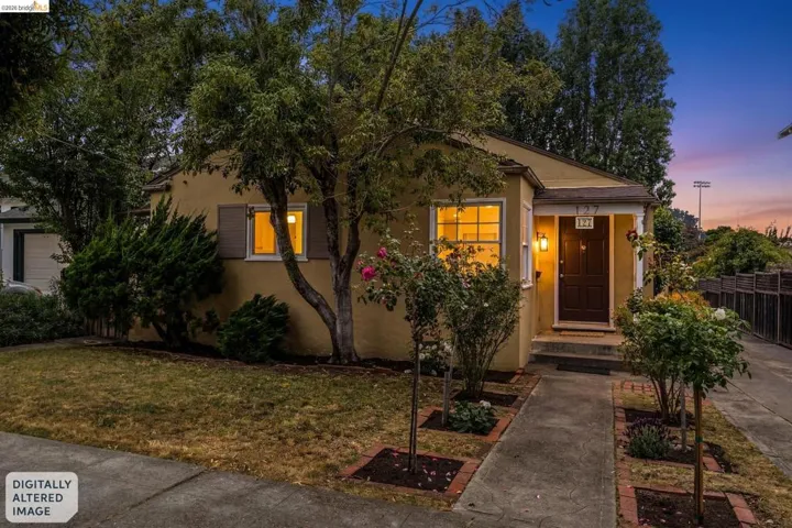 Warm-toned exterior with a covered entry, dark paneled door, and exterior lighting