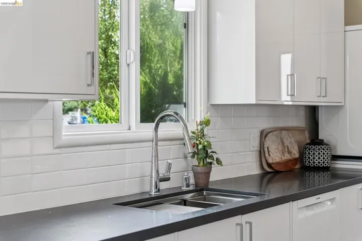 Stainless steel double-basin sink with a gooseneck faucet, set within a dark countertop
