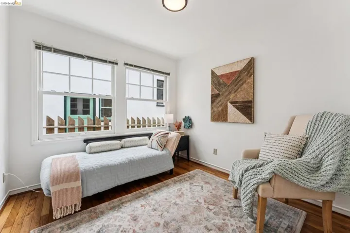 Hardwood flooring complements white walls and multiple windows