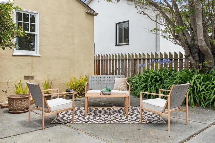 Concrete patio featuring a privacy fence, mature trees, and established plantings