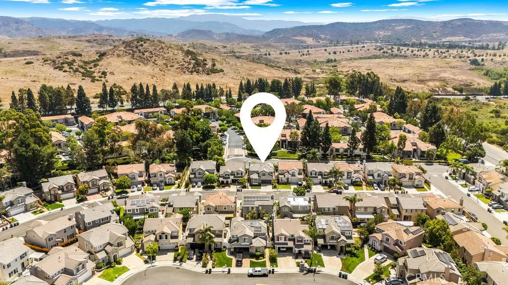 Elevated aerial view highlighting the neighborhood setting and nearby natural surroundings.