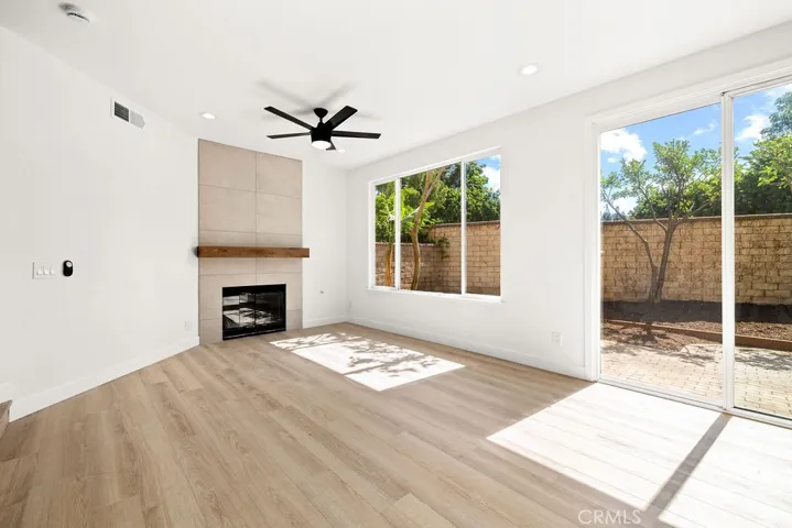 Sun-filled family room with large windows and sliding glass door providing backyard access.