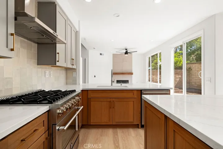Stainless steel appliances, warm tile backsplash, and oversized island create an ideal space for cooking and entertaining.