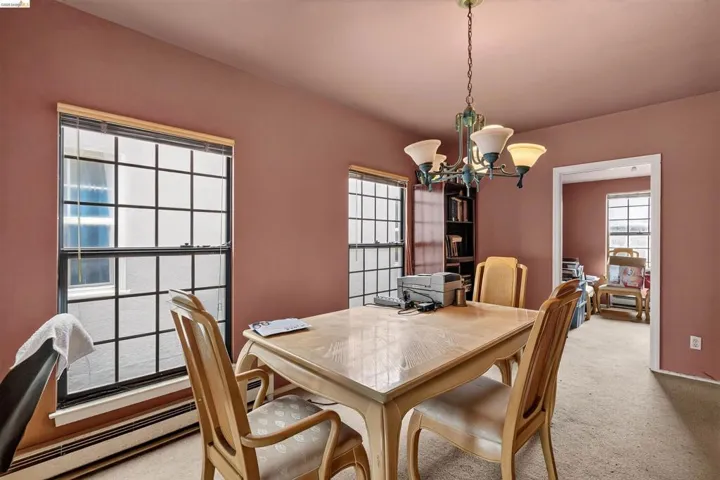 Interior room featuring two large grid windows, a built-in bookshelf, and an overhead chandelier with decorative shades