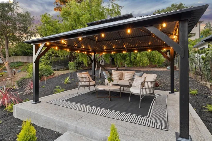 Outdoor covered patio featuring a dark metal roof and string lighting