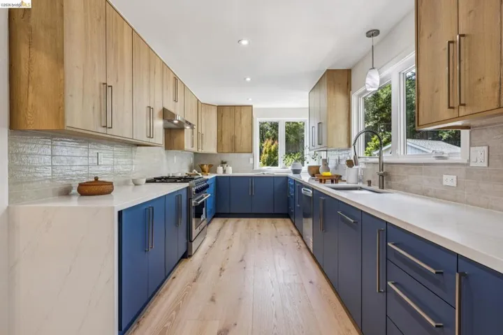 Modern kitchen featuring wood-finish upper cabinetry and blue lower cabinetry
