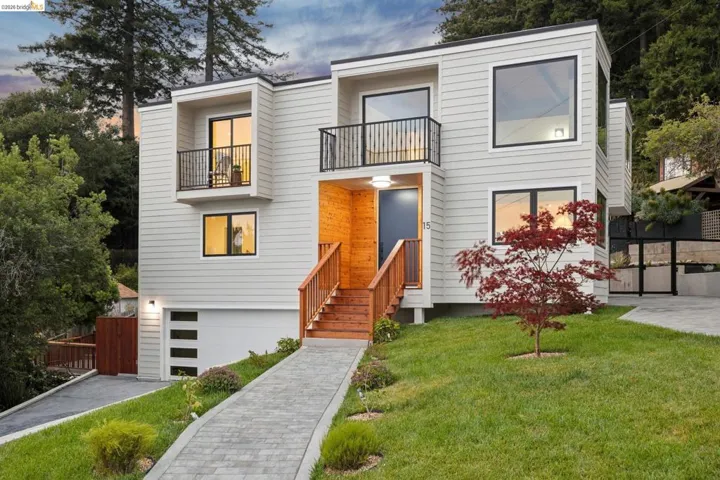 Contemporary architectural design featuring light-colored siding, black-framed windows, and multiple balconies with dark railings
