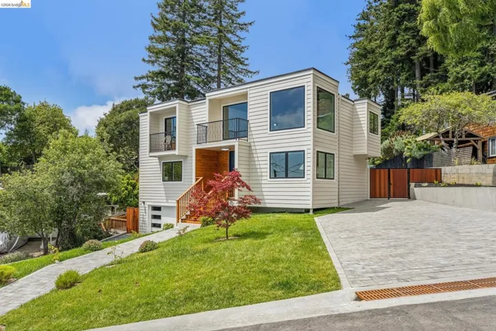 Contemporary exterior featuring crisp white siding, multiple balconies with black railings, and an integrated garage