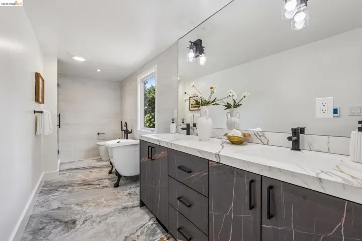 Double vanity with integrated sinks, marble-patterned countertops, and matte black fixtures