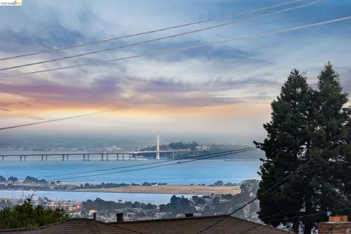 Expansive water views with a prominent suspension bridge and distant city skyline