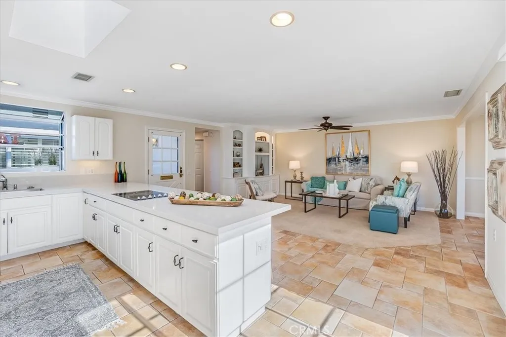 Quartz peninsula in kitchen has stovetop and plenty of storage.