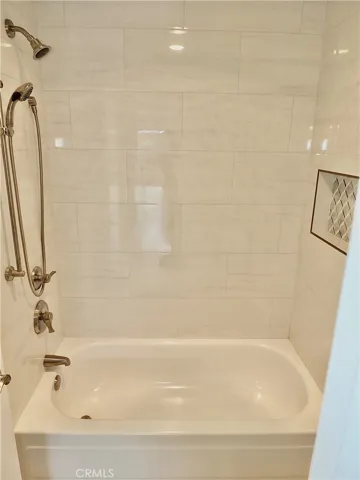 Bathtub with dual showerheads and tiled niche