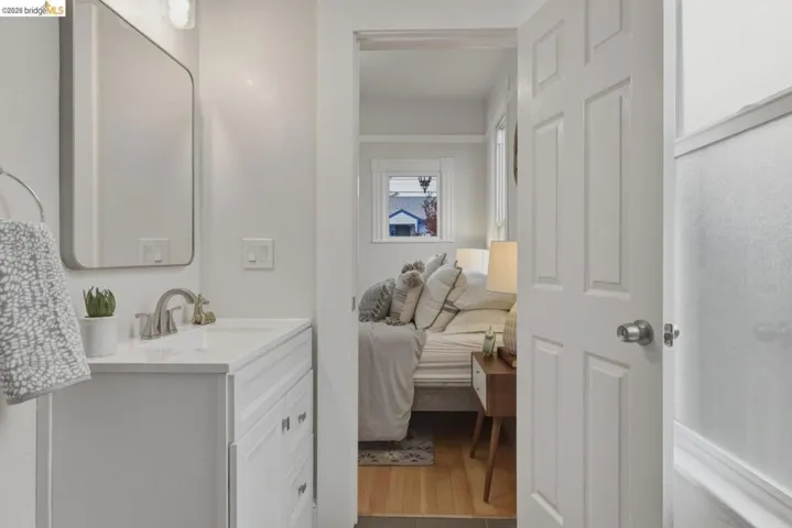 Bathroom vanity with white cabinetry, a white countertop, and a brushed nickel faucet
