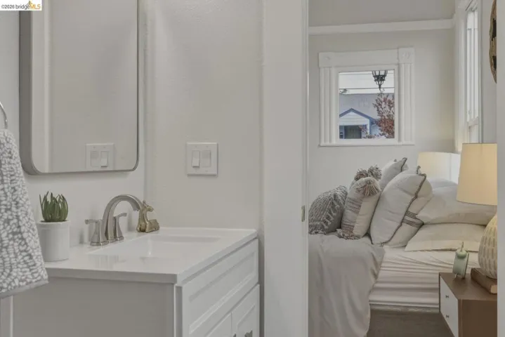 Bathroom vanity featuring a rectangular sink, brushed nickel faucet, and a wall-mounted mirror