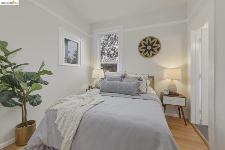 Hardwood flooring, painted trim and crown molding, white walls, and bright windows