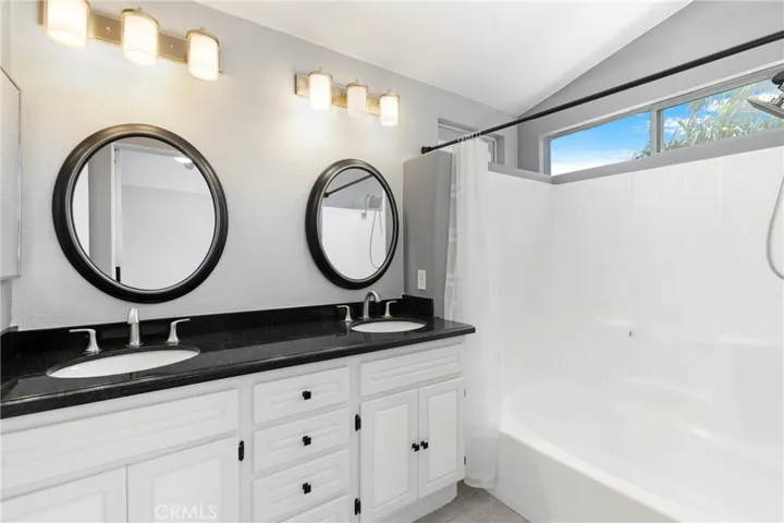 Primary Bathroom with Dual Sinks, shower in the tub.