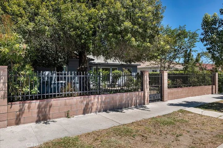 This home has front secured perimeter of brick wall and iron fencing